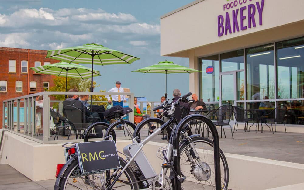 Modern commercial building with outdoor seating and bike racks.