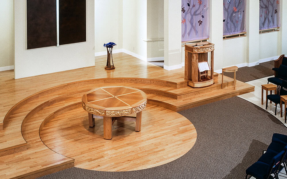 Interior view of First Congregational Church with wooden stage and seating area.