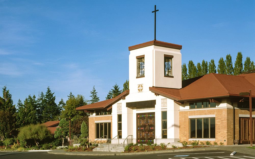 Modern church building with a prominent cross and welcoming entrance.