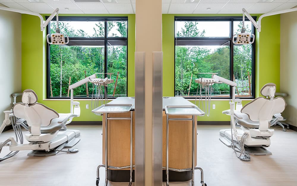 Dental treatment rooms with advanced equipment and natural light for patient comfort.