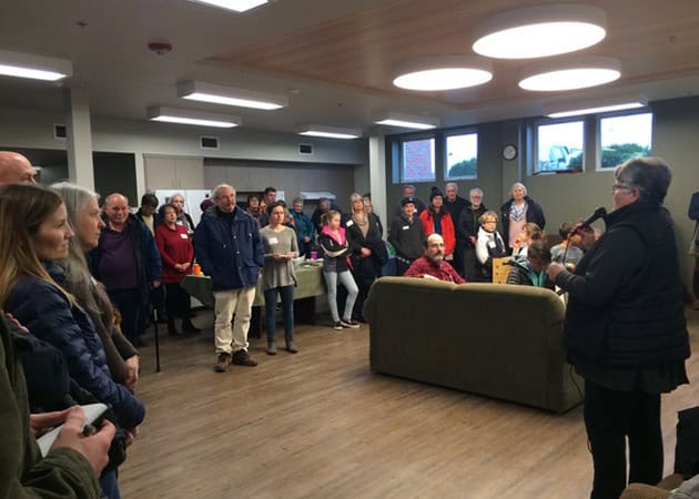 Community gathering at youth shelter opening during cold snap, organized by RMC Architects.