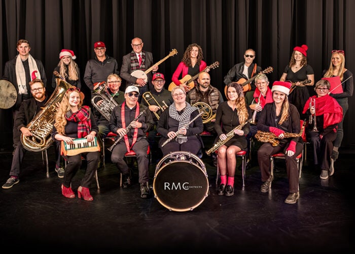 RMC Architects holiday sing-along group performing festive music on stage.