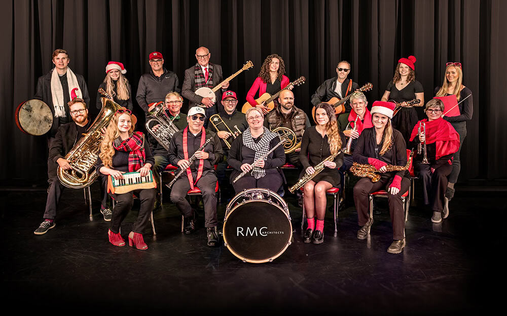 RMC Architects holiday sing-along group performing festive music on stage.